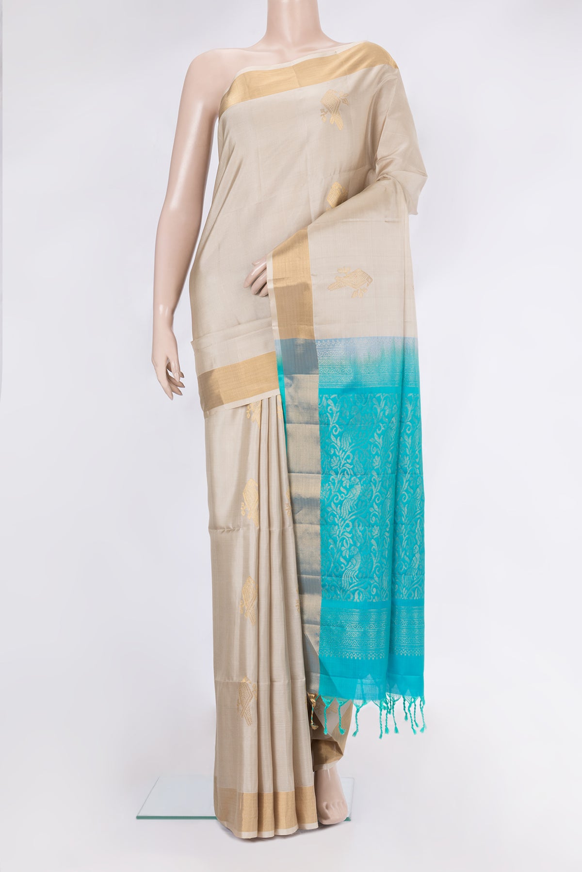 Beige Soft Silk Saree with Zari Butta on the body and Zari Border.  displayed on a mannequin