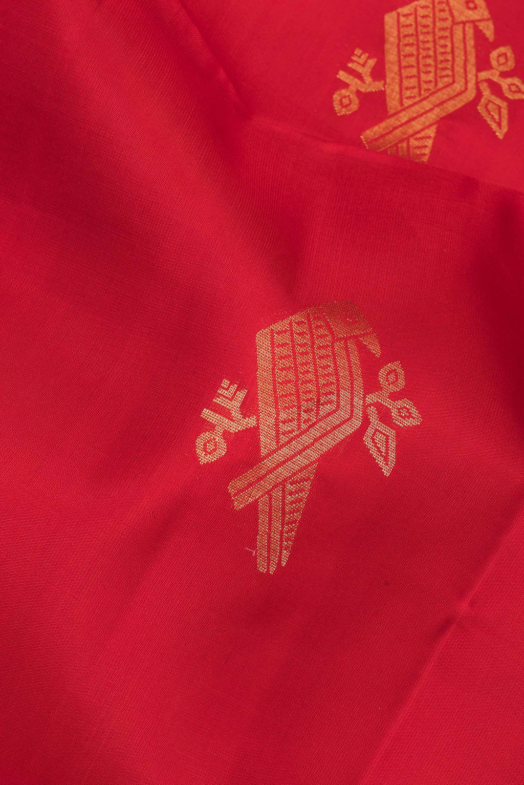 Close up of Pure Silk Red Soft Saree with Zari Butta on the body and Zari Border.  displaying folds