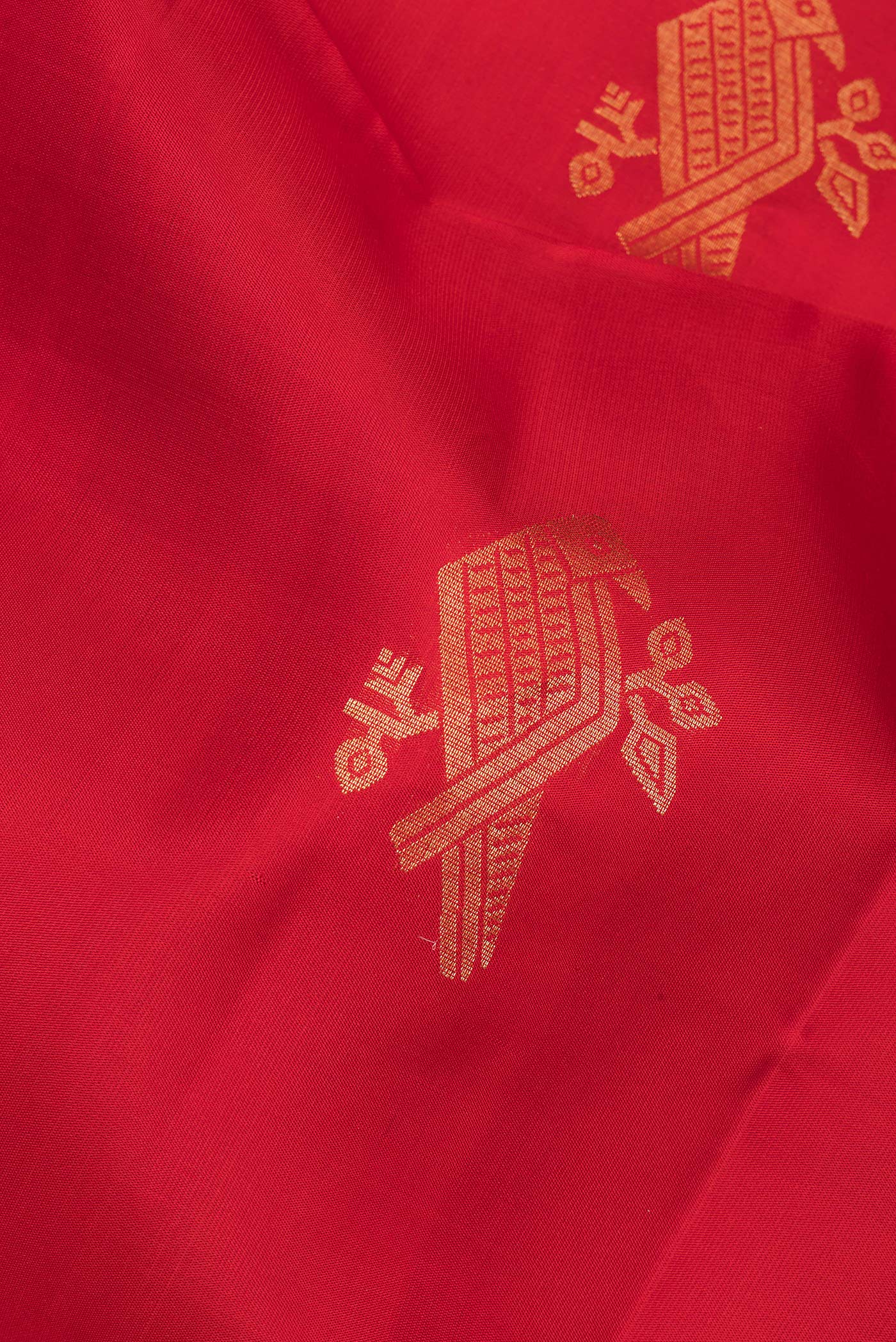Close up of Pure Silk Red Soft Saree with Zari Butta on the body and Zari Border.  displaying folds