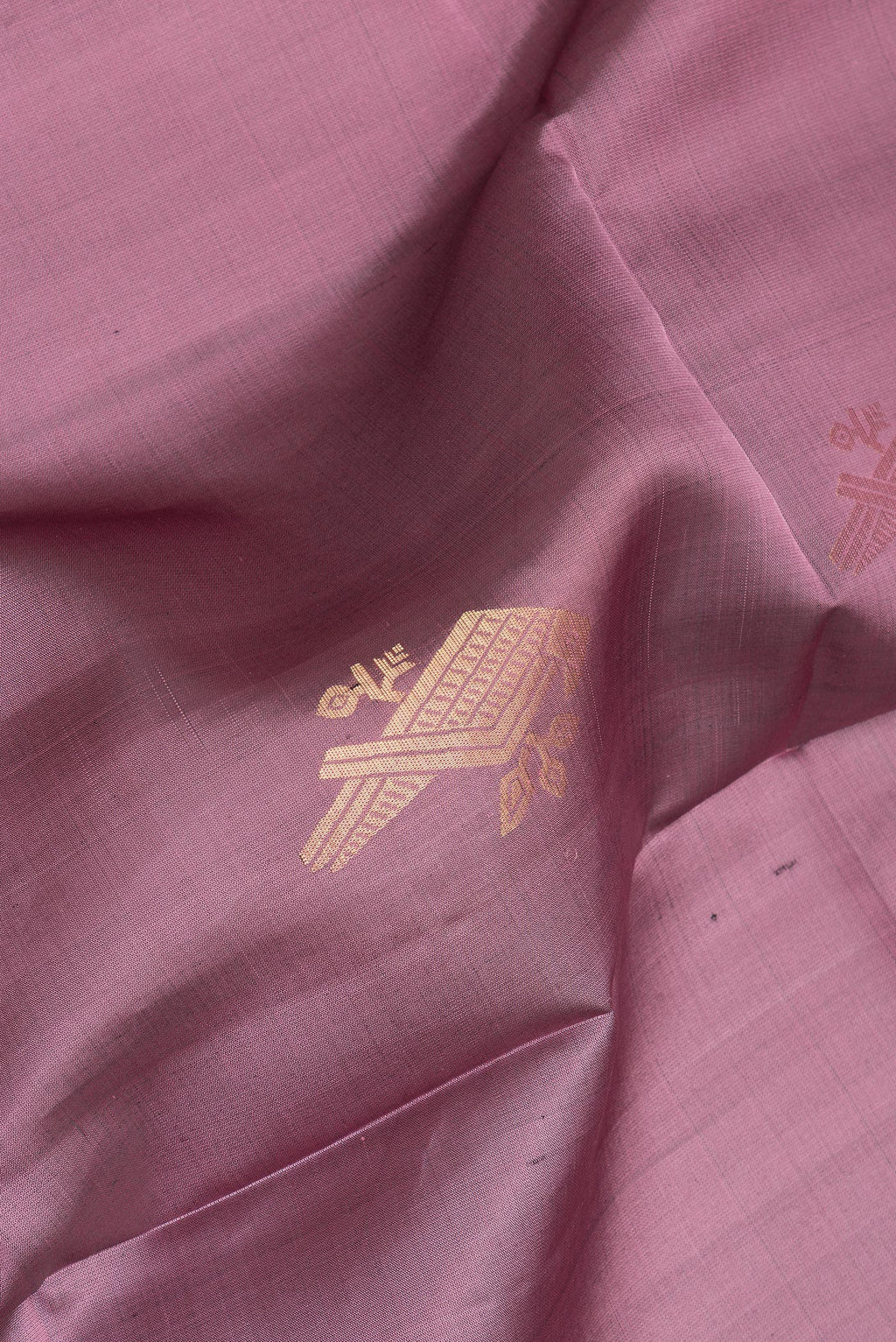 Close up of Pure Silk Mauve Soft Saree with Zari Butta on the body and Zari Border.  displaying folds