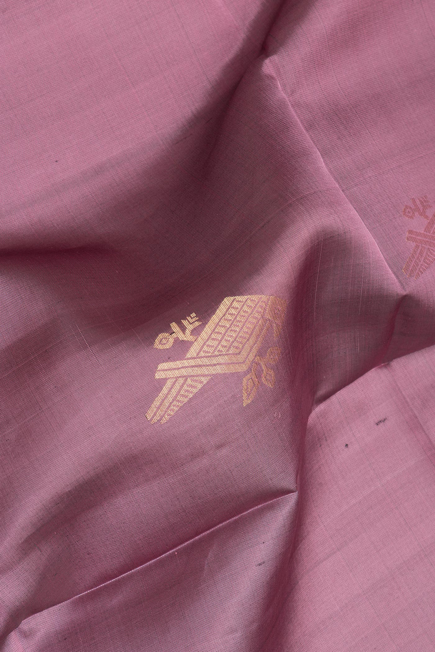 Close up of Pure Silk Mauve Soft Saree with Zari Butta on the body and Zari Border.  displaying folds
