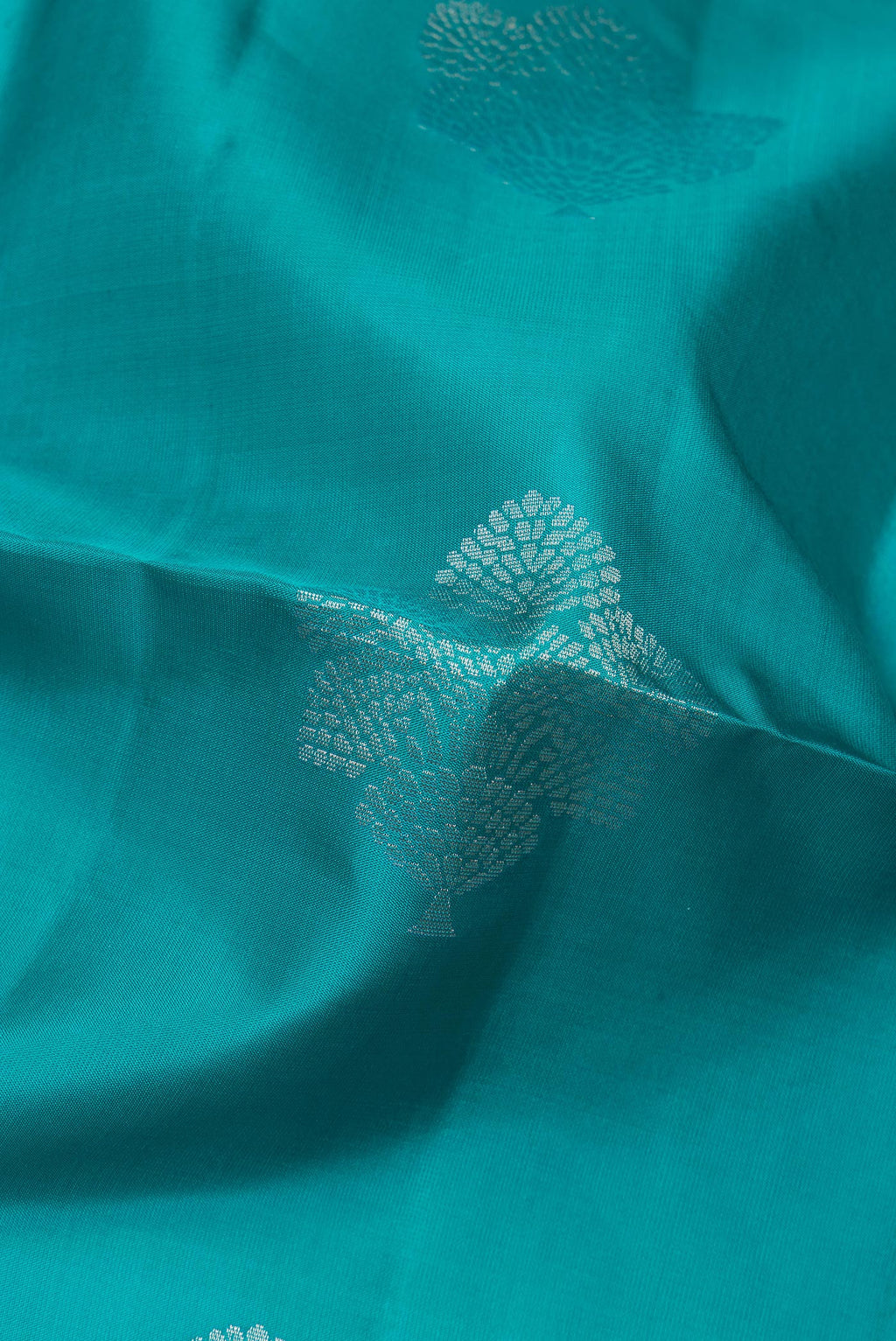 Close up of Pure Silk Peacock Blue Soft Saree with Zari Butta on the body and Zari Border.  displaying folds