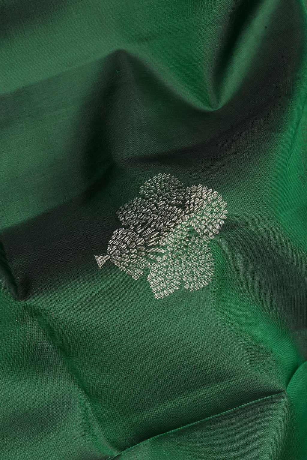 Close up of Pure Silk Bottle Green Soft Saree with Zari Butta on the body and Zari Border.  displaying folds