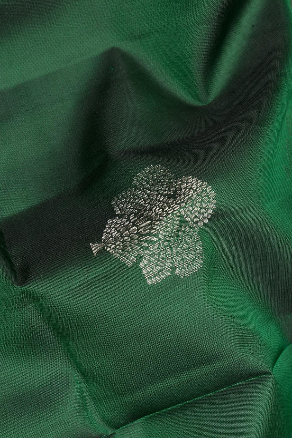 Close up of Pure Silk Bottle Green Soft Saree with Zari Butta on the body and Zari Border.  displaying folds