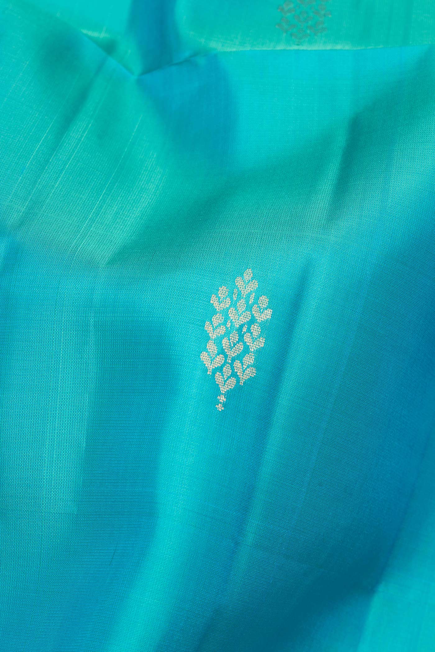 Close up of Pure Silk Sky Blue Soft Saree with Zari Butta on the body and Zari Border.  displaying folds