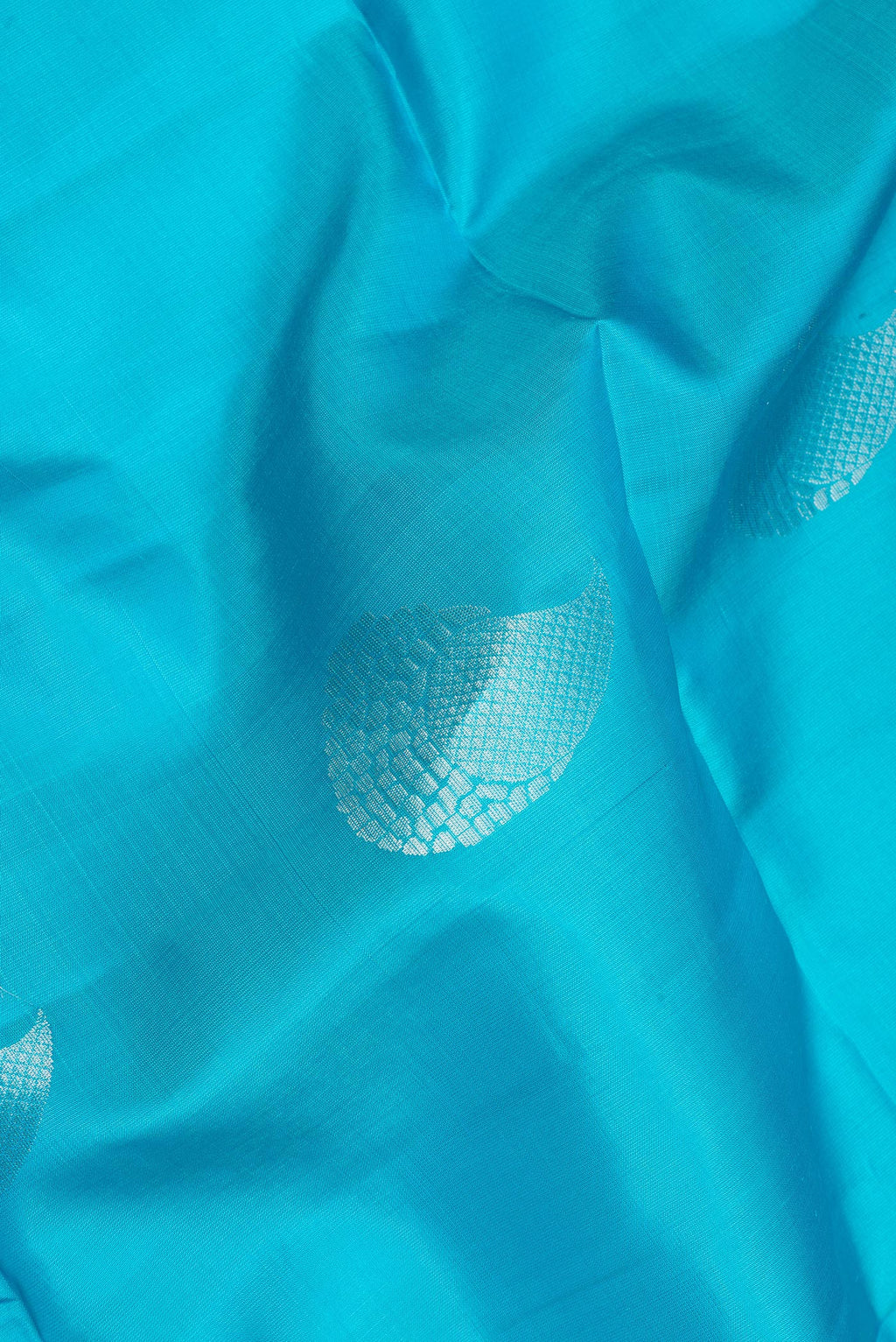 Close up of Pure Silk Sky Blue Soft Saree with Zari Butta on the body and Zari Border.  displaying folds