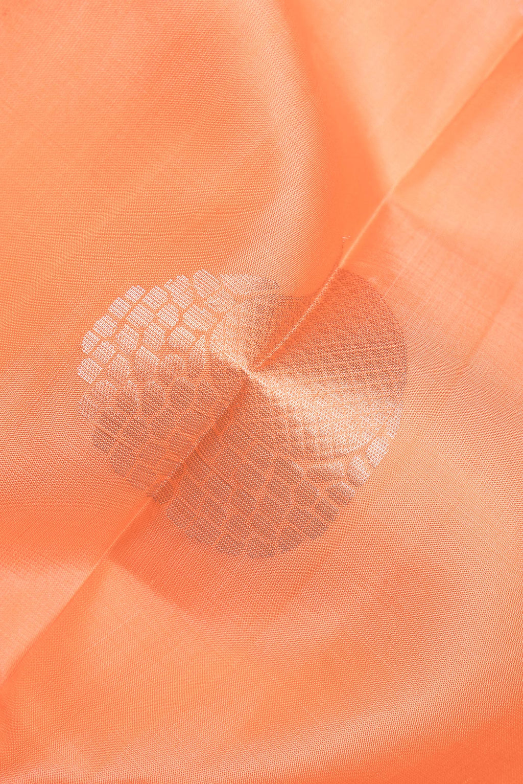 Close up of Pure Silk Orange Soft Saree with Zari Butta on the body and Zari Border.  displaying folds