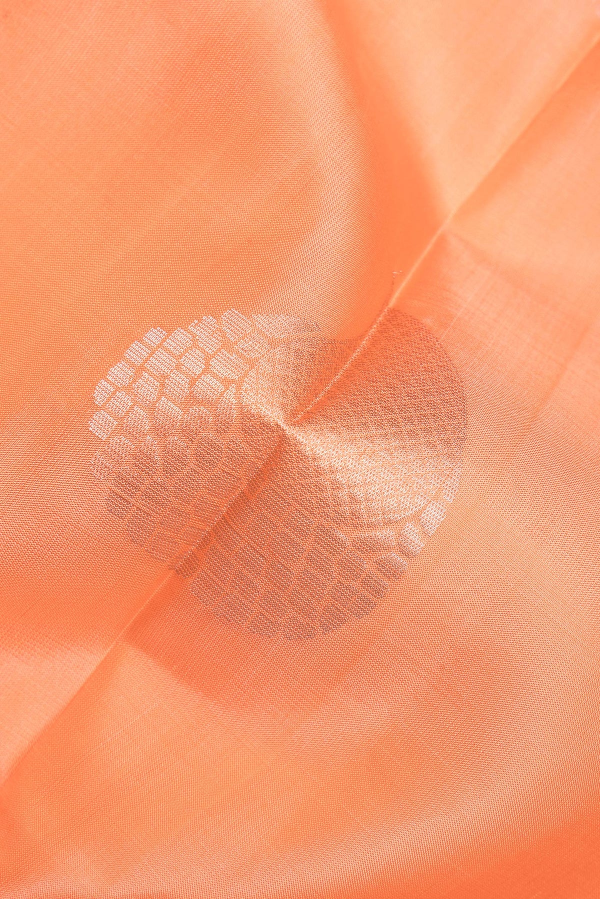 Close up of Pure Silk Orange Soft Saree with Zari Butta on the body and Zari Border.  displaying folds