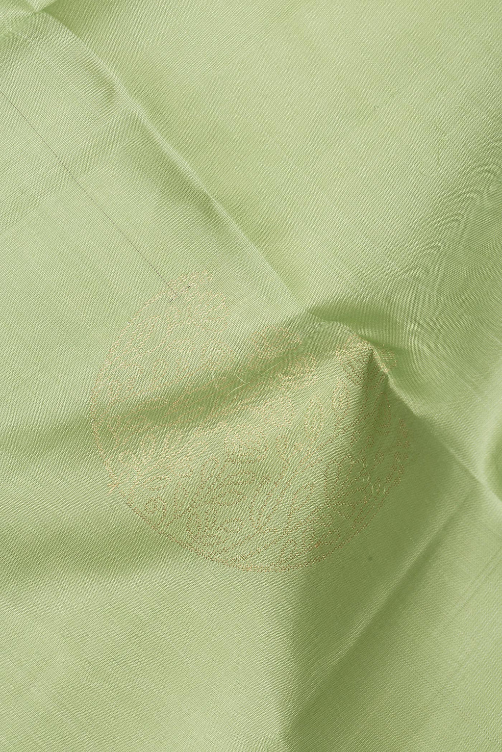Close up of Pure Silk Pista Green Soft Saree with Zari Butta on the body and Zari Border.  displaying folds