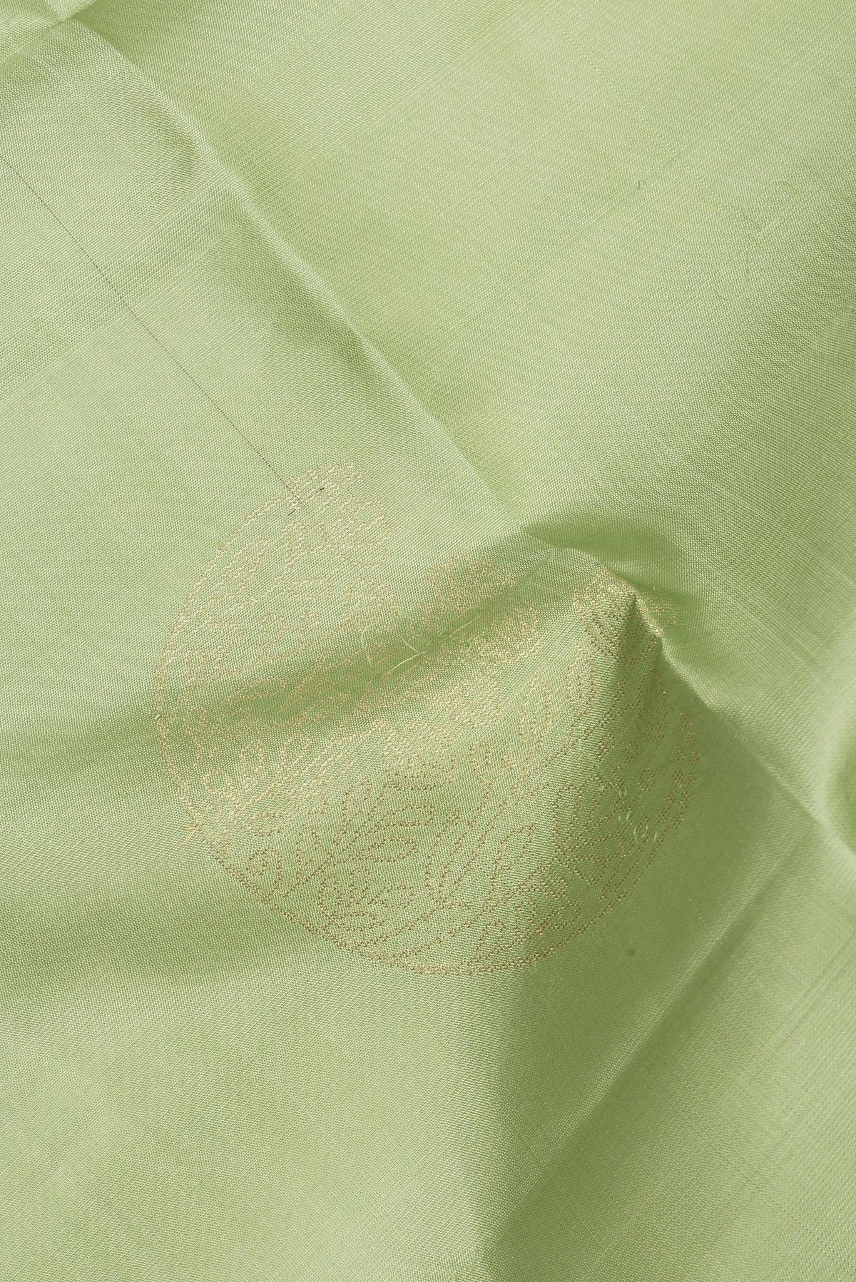 Close up of Pure Silk Pista Green Soft Saree with Zari Butta on the body and Zari Border.  displaying folds
