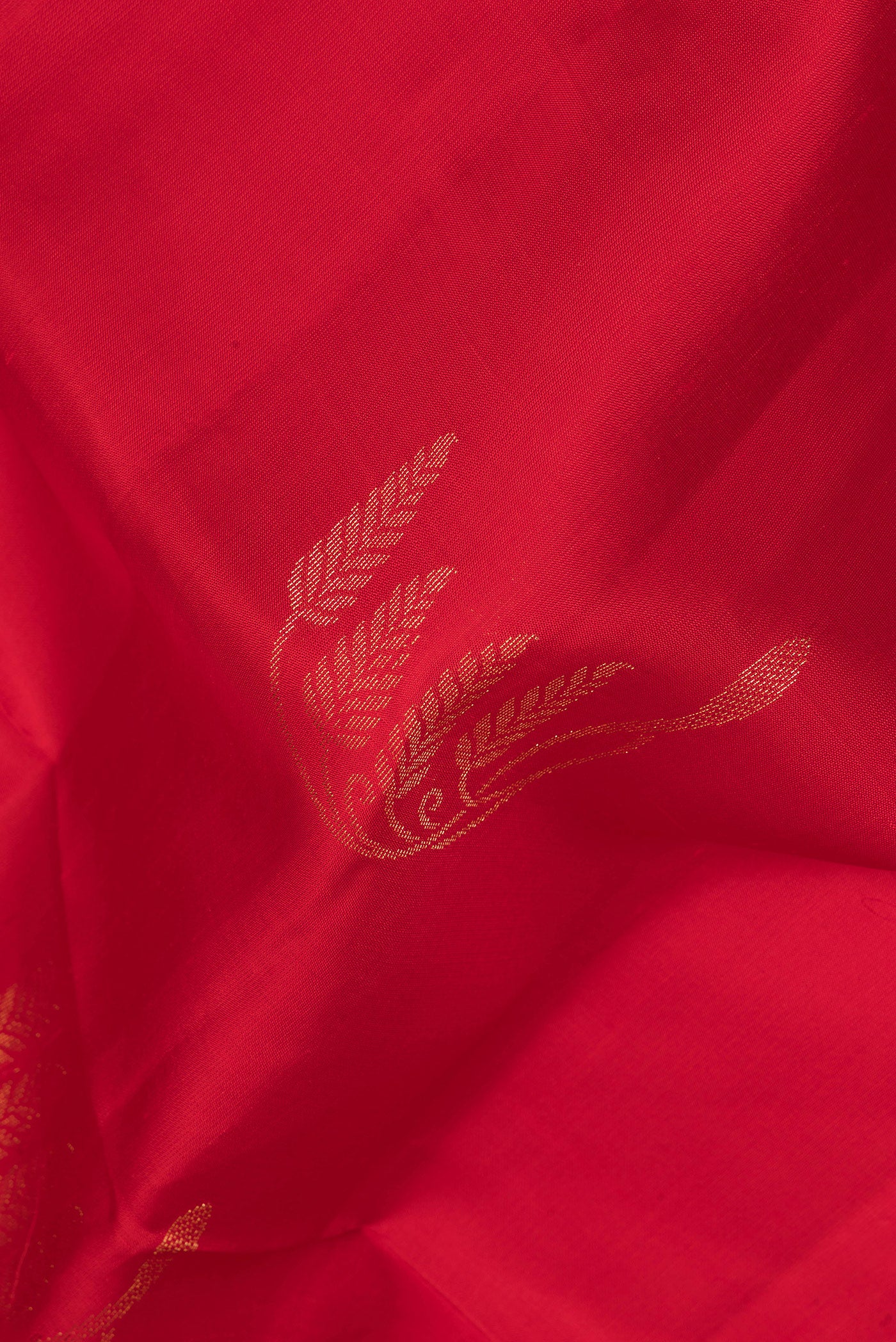 Close up of Pure Silk Red Soft Saree with Zari Butta on the body and Zari Border.  displaying folds