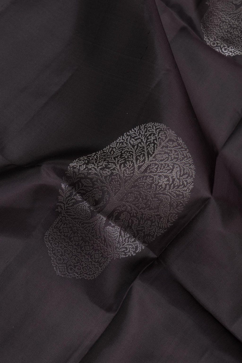 Close up of Pure Silk Black Soft Saree with Zari Butta on the body and Zari Border.  displaying folds