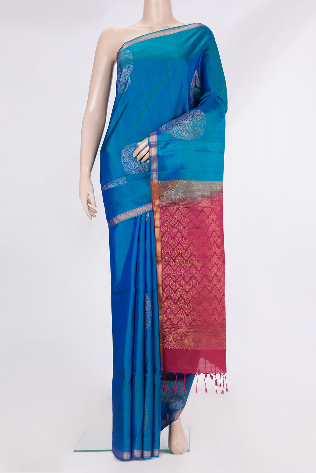 Pure Silk Peacock Blue Soft Saree with Zari Butta on the body and Zari Border.  displayed on a mannequin