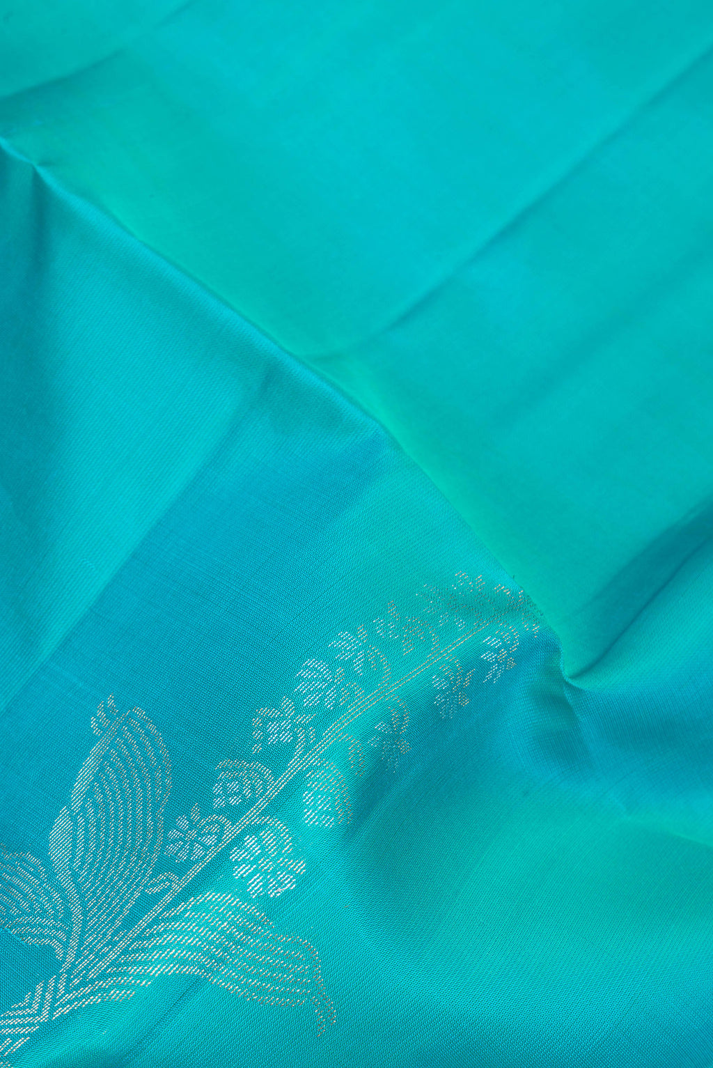 Close up of Sky Blue Soft Silk Saree with Zari Butta on the body and Zari Border.  displaying folds