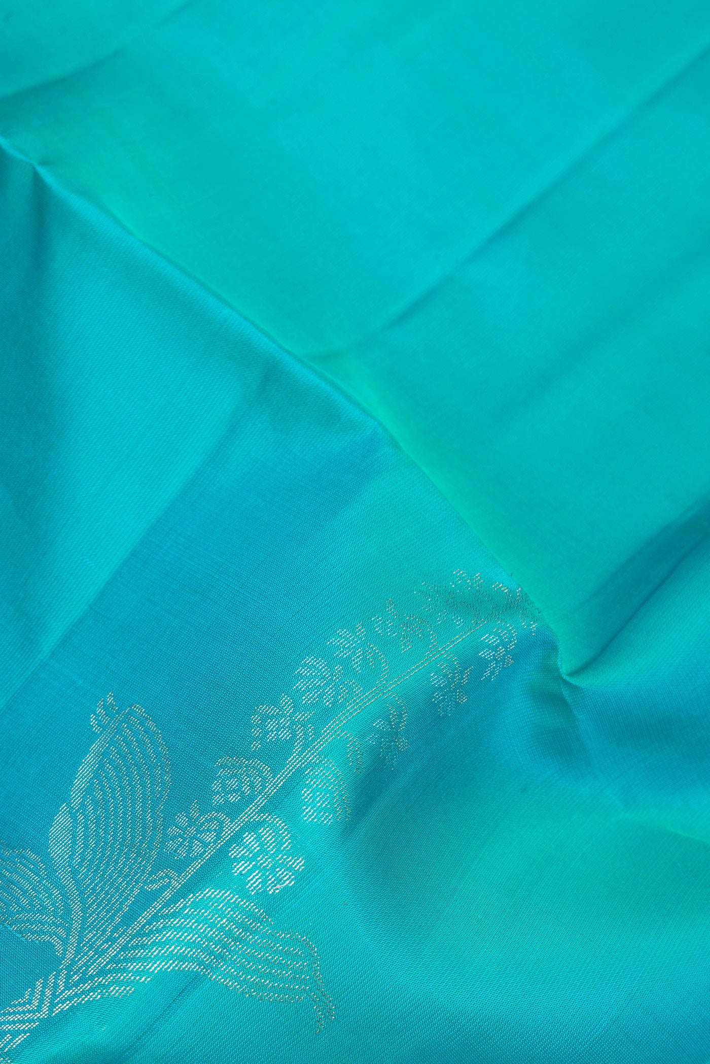 Close up of Sky Blue Soft Silk Saree with Zari Butta on the body and Zari Border.  displaying folds