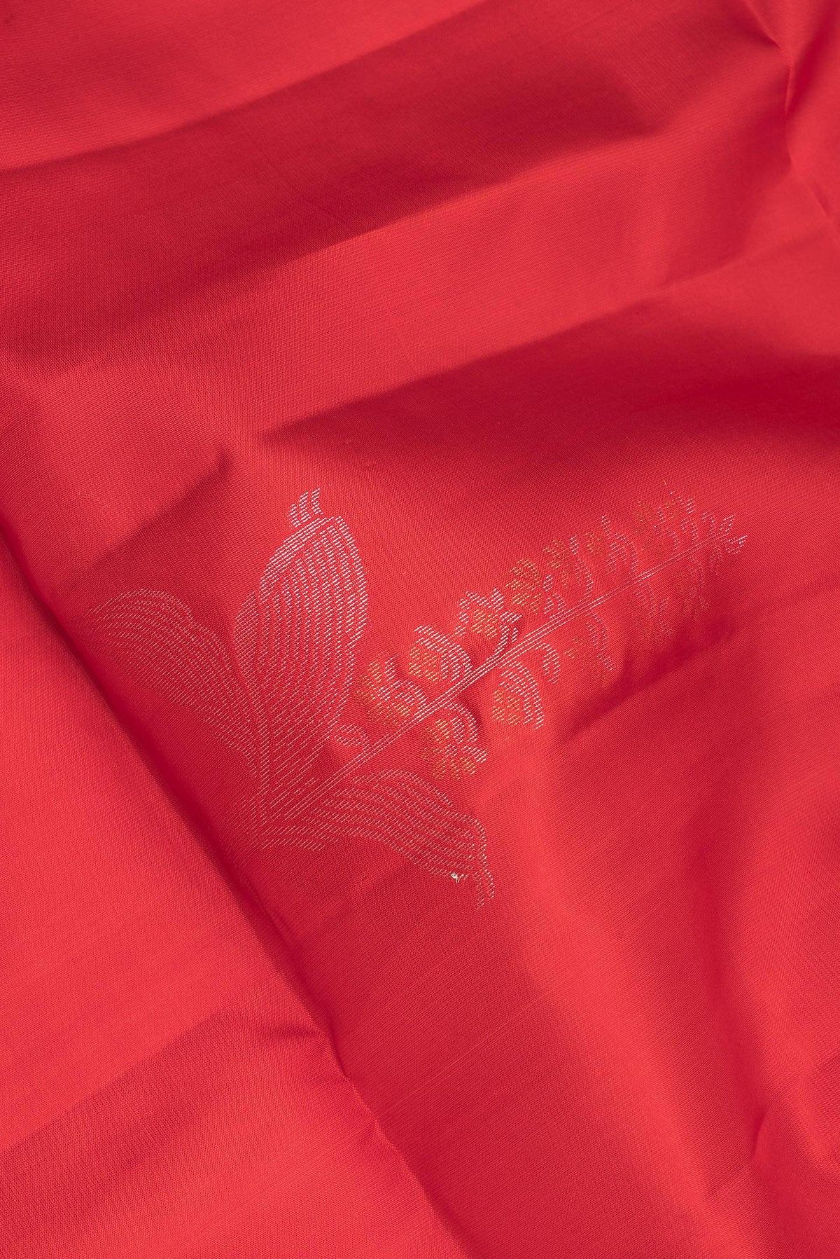Close up of Pure Silk Red Soft Saree with Zari Butta on the body and Zari Border.  displaying folds