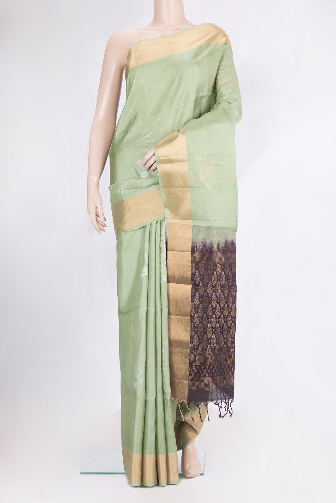 Pure Silk Pista Green Soft Saree with Zari Butta on the body and Zari Border.  displayed on a mannequin