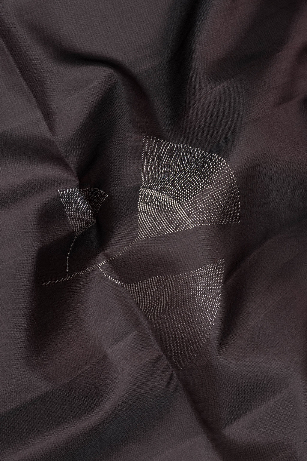 Close up of Pure Silk Black Soft Saree with Zari Butta on the body and Zari Border.  displaying folds