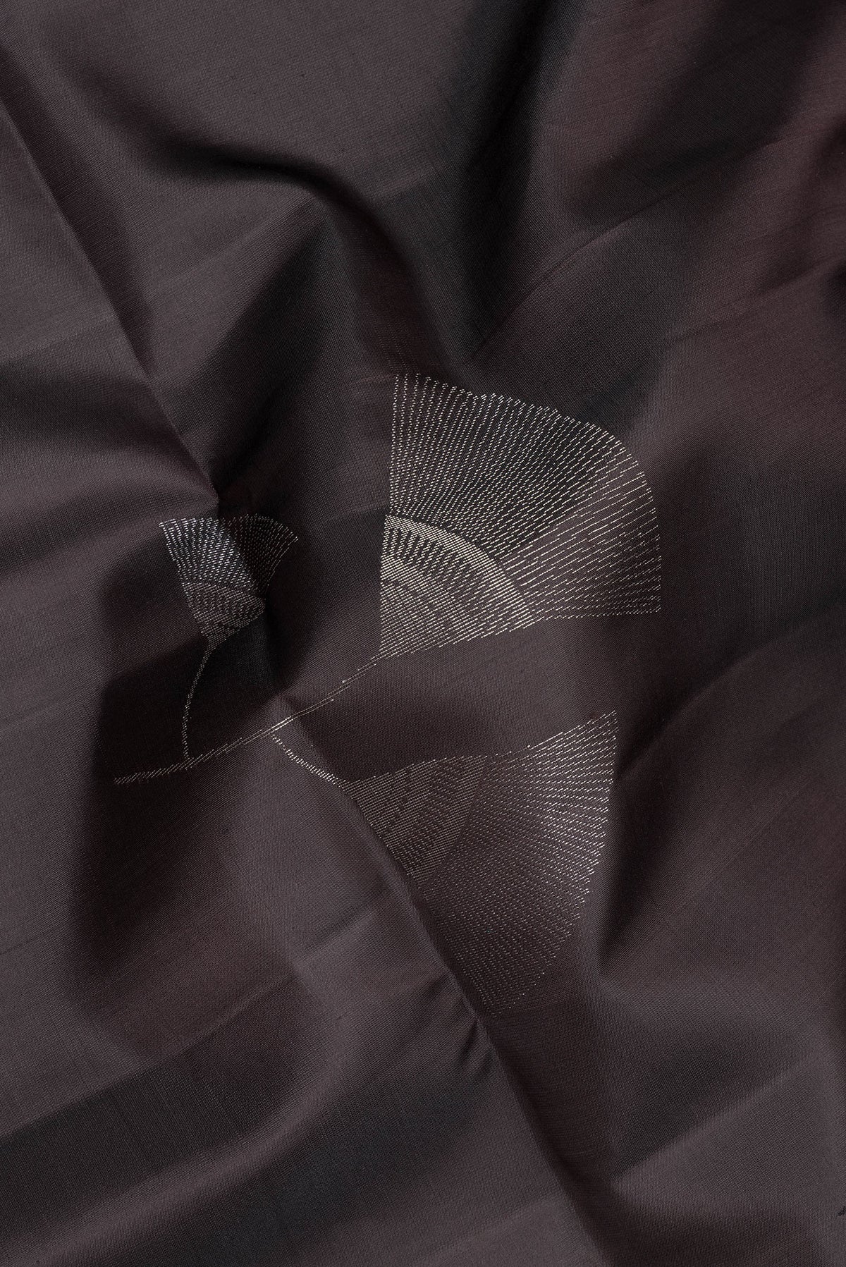 Close up of Pure Silk Black Soft Saree with Zari Butta on the body and Zari Border.  displaying folds