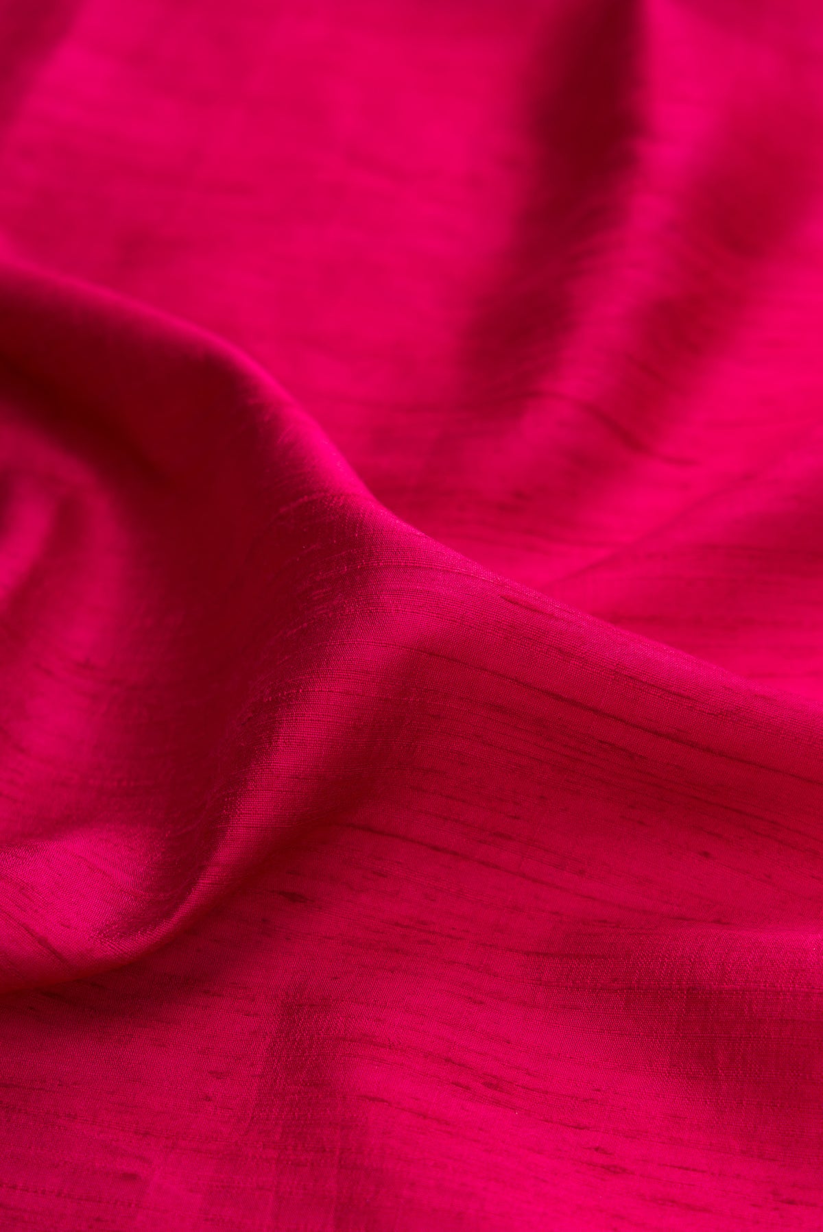 Close up of Rani Pink Tussar Saree with Plain Body and Fancy Border.  displaying folds