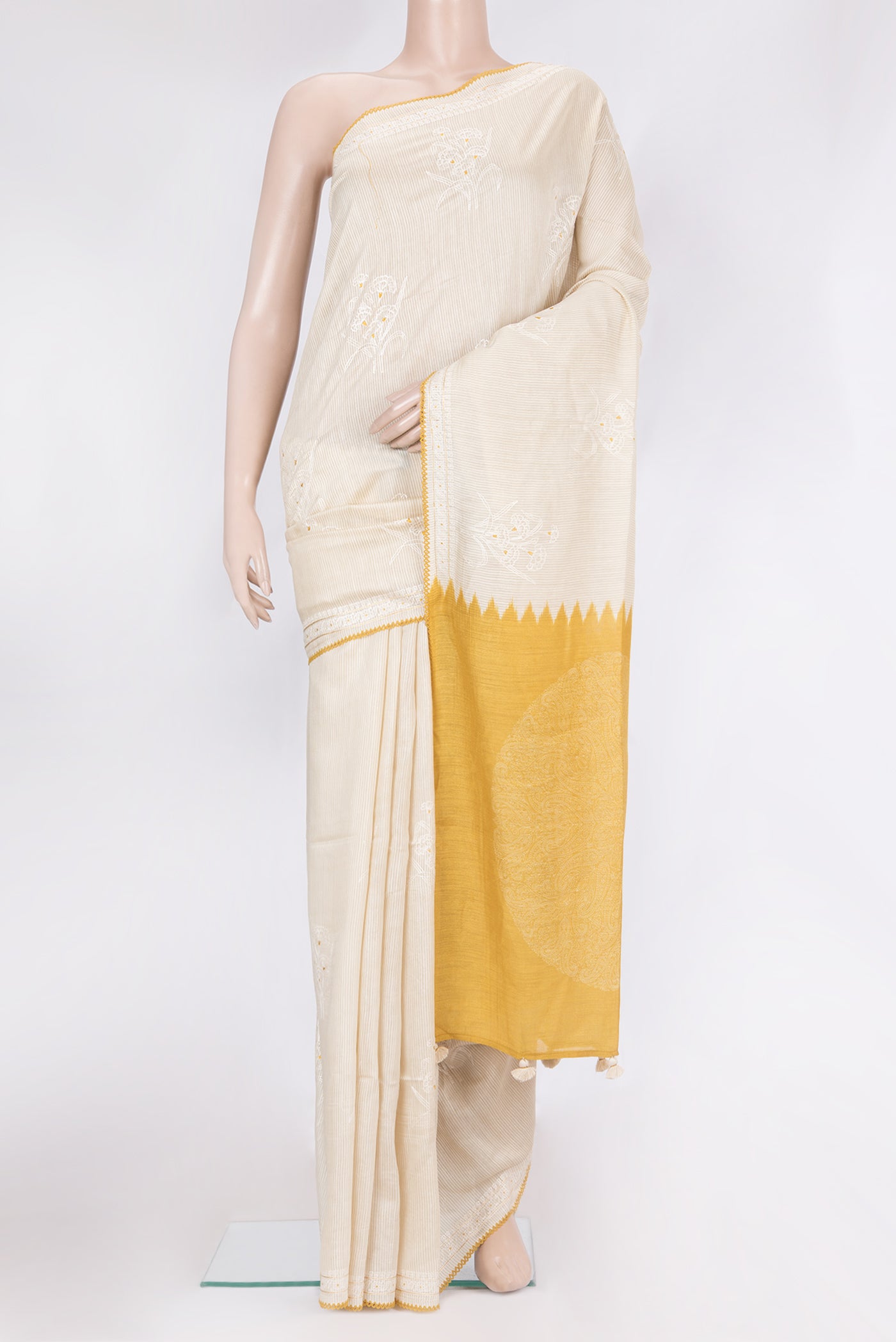 Beige Tussar Saree with Embroidery on the body and Embroidery Border.  displayed on a mannequin