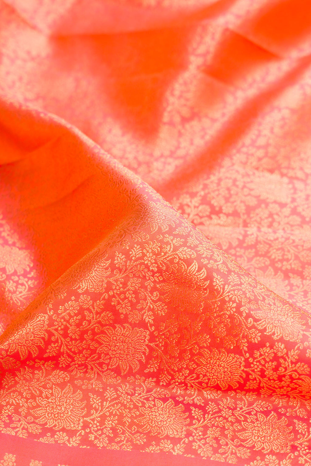 Close up of Coral Dual Tone Kanchipuram Silk Saree with Zari Brocade on the body and Zari Border.  displaying folds
