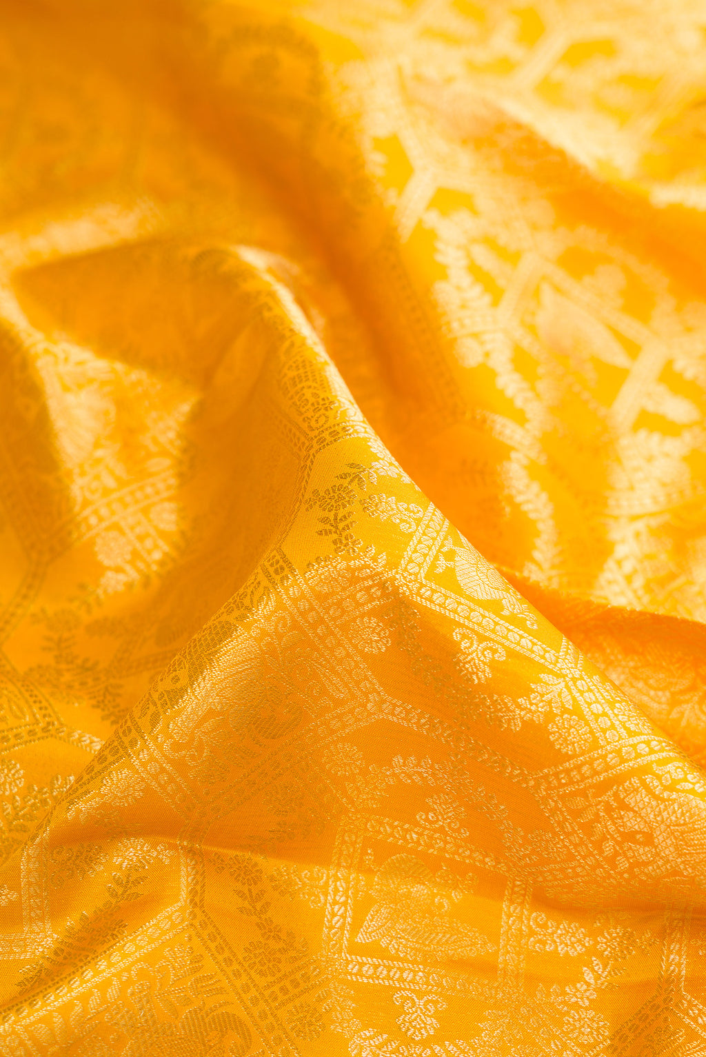 Close up of Pure Silk Yellow Kanchipuram Saree with Zari Brocade on the body and Zari Border.  displaying folds