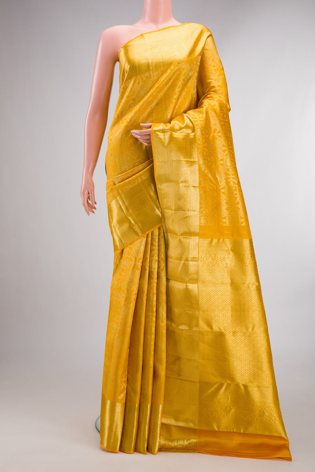 Pure Silk Yellow Kanchipuram Saree with Zari Brocade on the body and Zari Border.  displayed on a mannequin