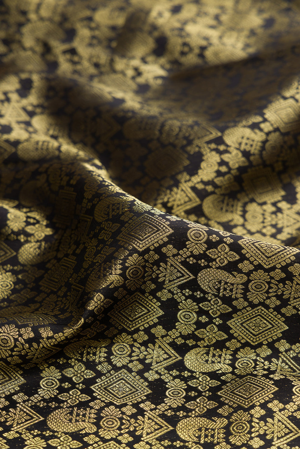 Close up of Pure Silk Black Kanchipuram Saree with Zari Brocade on the body and Zari Border.  displaying folds