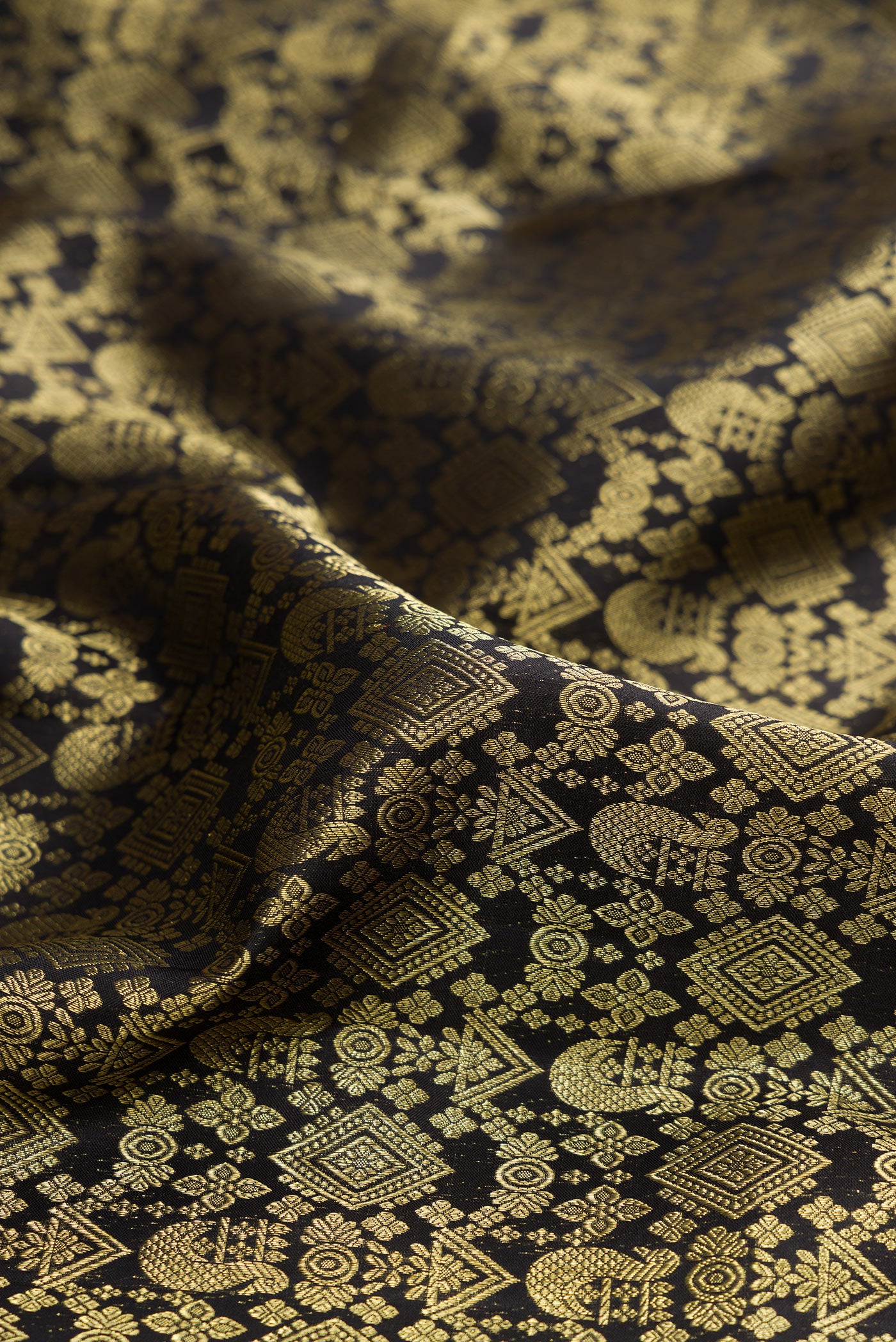 Close up of Pure Silk Black Kanchipuram Saree with Zari Brocade on the body and Zari Border.  displaying folds