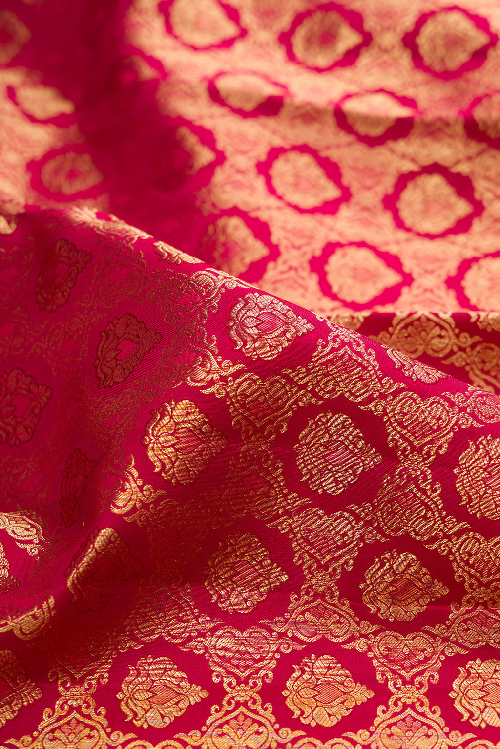 Close up of Pure Silk Rani Pink Kanchipuram Saree with Zari Brocade on the body and Zari Border.  displaying folds