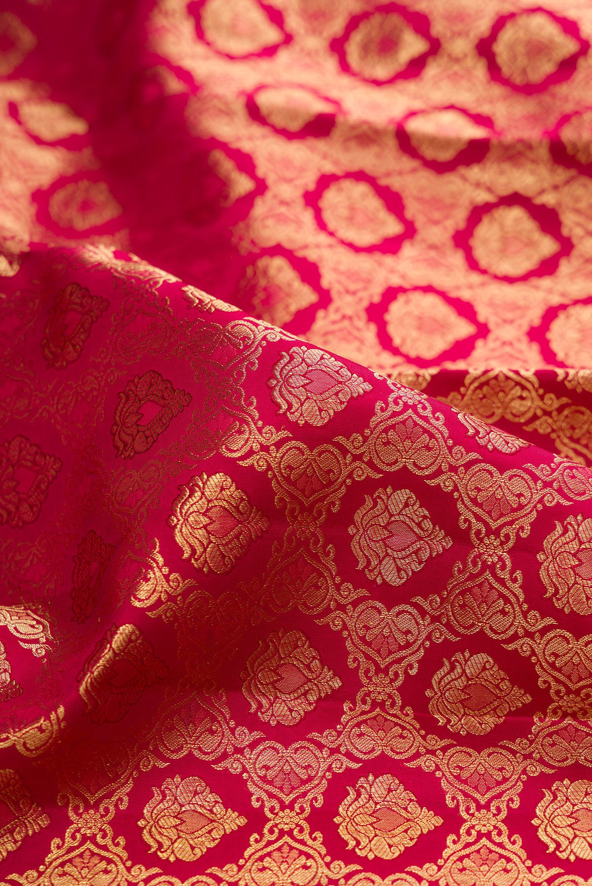 Close up of Pure Silk Rani Pink Kanchipuram Saree with Zari Brocade on the body and Zari Border.  displaying folds