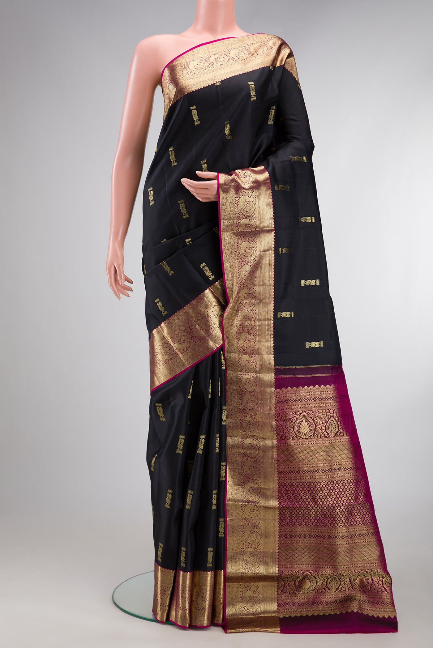 Black Kanchipuram Silk Saree with Zari Butta on the body and Zari Border.  displayed on a mannequin