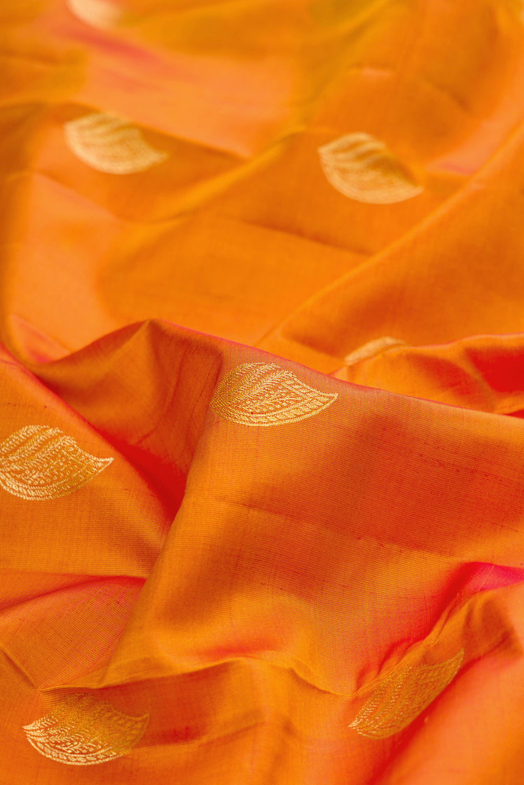 Close up of Pure Silk Mustard Kanchipuram Saree with Zari Butta on the body and Zari Border.  displaying folds
