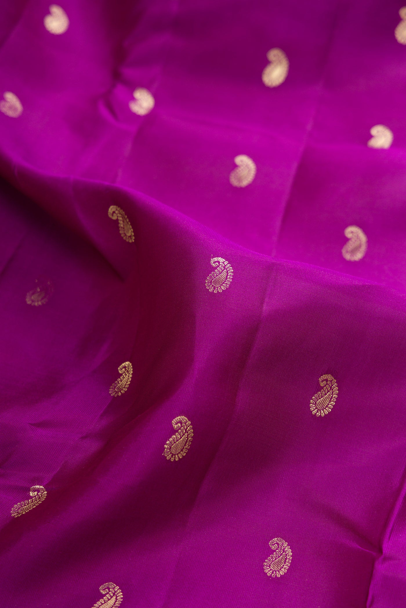 Close up of Purple Kanchipuram Silk Saree with Zari Butta on the body and Zari Border.  displaying folds