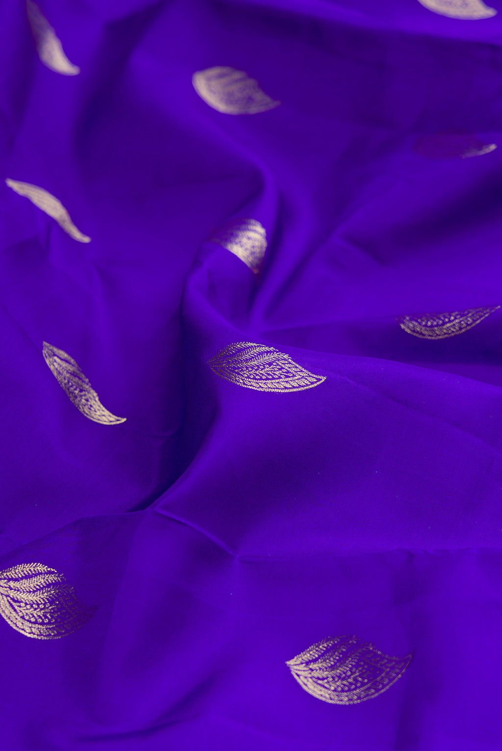 Close up of Pure Silk Royal Blue Kanchipuram Saree with Zari Butta on the body and Zari Border.  displaying folds
