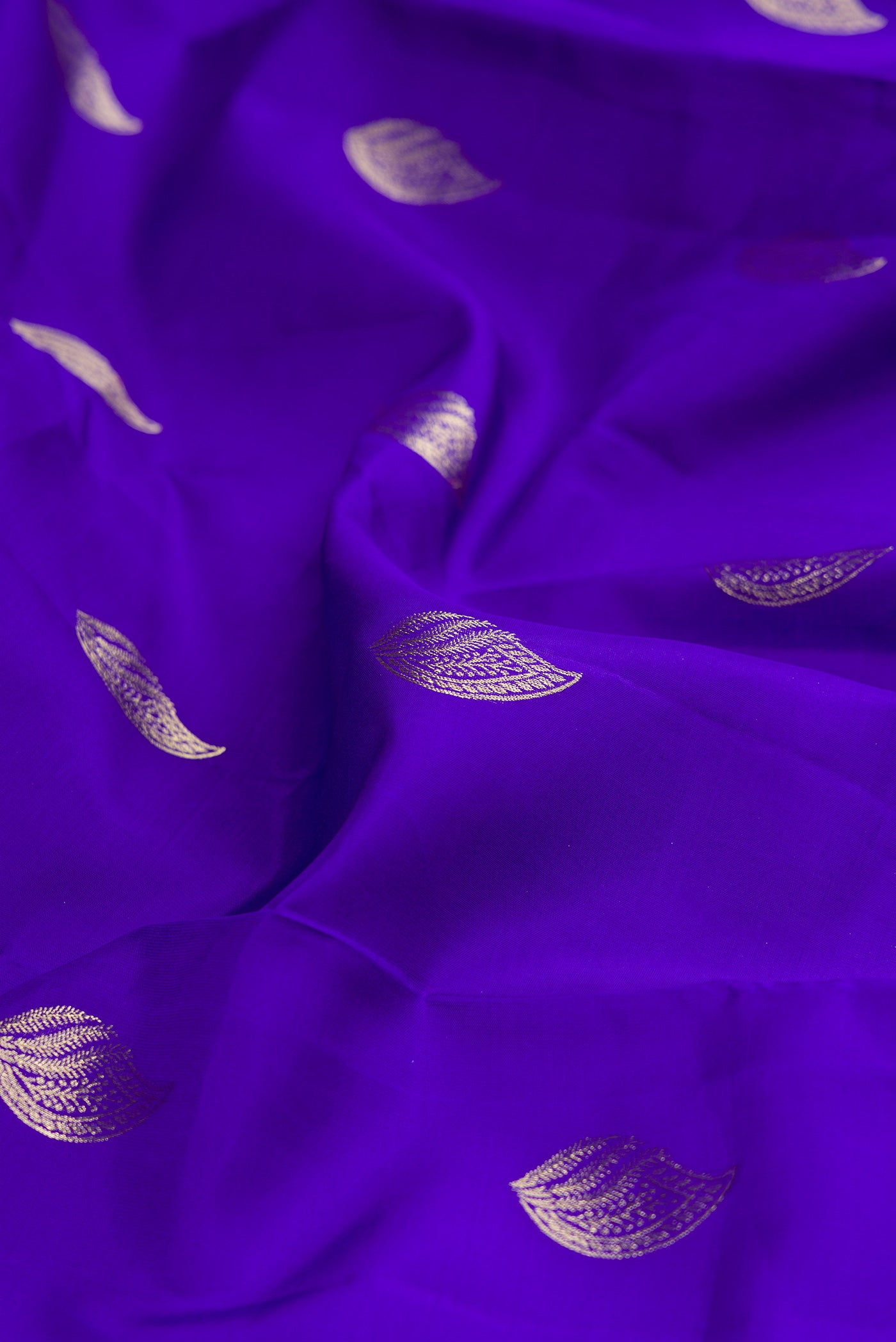 Close up of Pure Silk Royal Blue Kanchipuram Saree with Zari Butta on the body and Zari Border.  displaying folds
