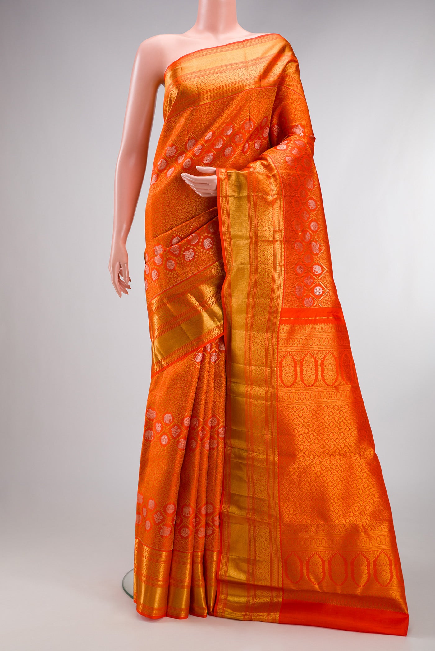 Orange Kanjivaram Silk Saree with Zari Brocade on the body and Zari Border.  displayed on a mannequin