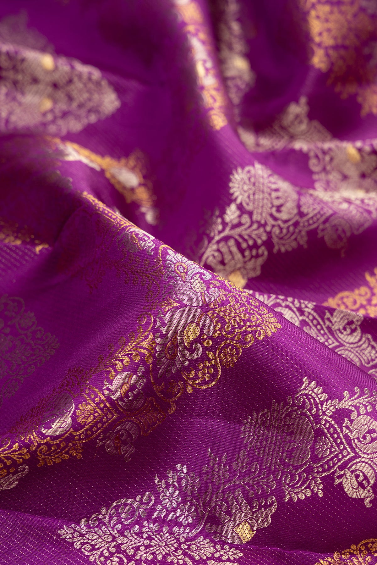 Close up of Pure Silk Purple Kanjivaram Saree with Zari Brocade on the body and Zari Border.  displaying folds