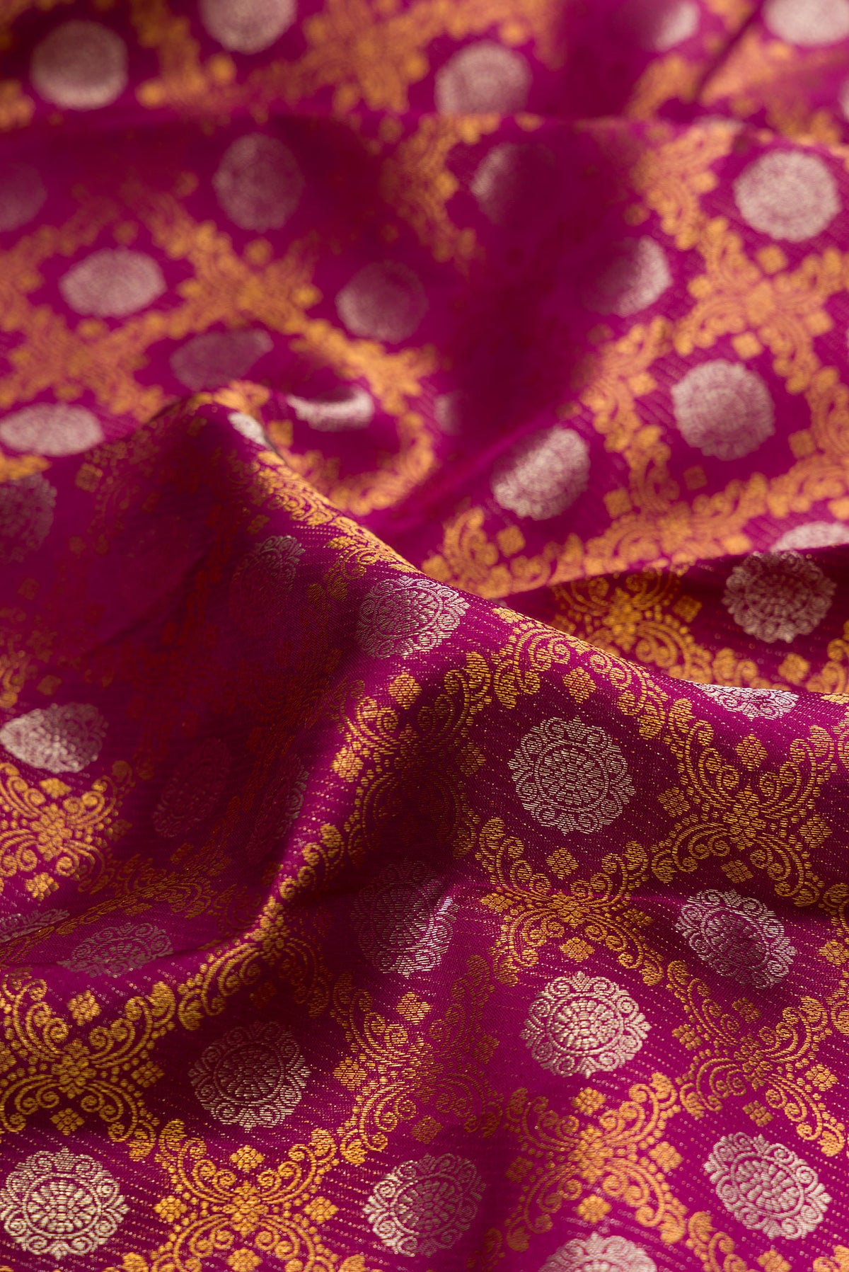 Close up of Pure Silk Magenta Kanjivaram Saree with Zari Brocade on the body and Zari Border.  displaying folds