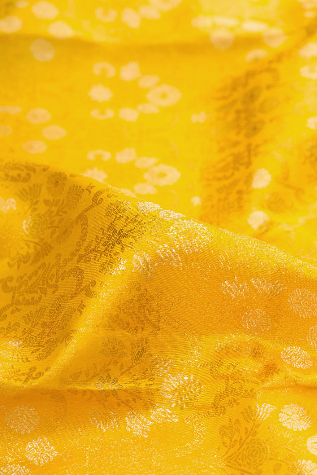 Close up of Pure Silk Mustard Kanjivaram Saree with Zari Brocade on the body and Zari Border.  displaying folds