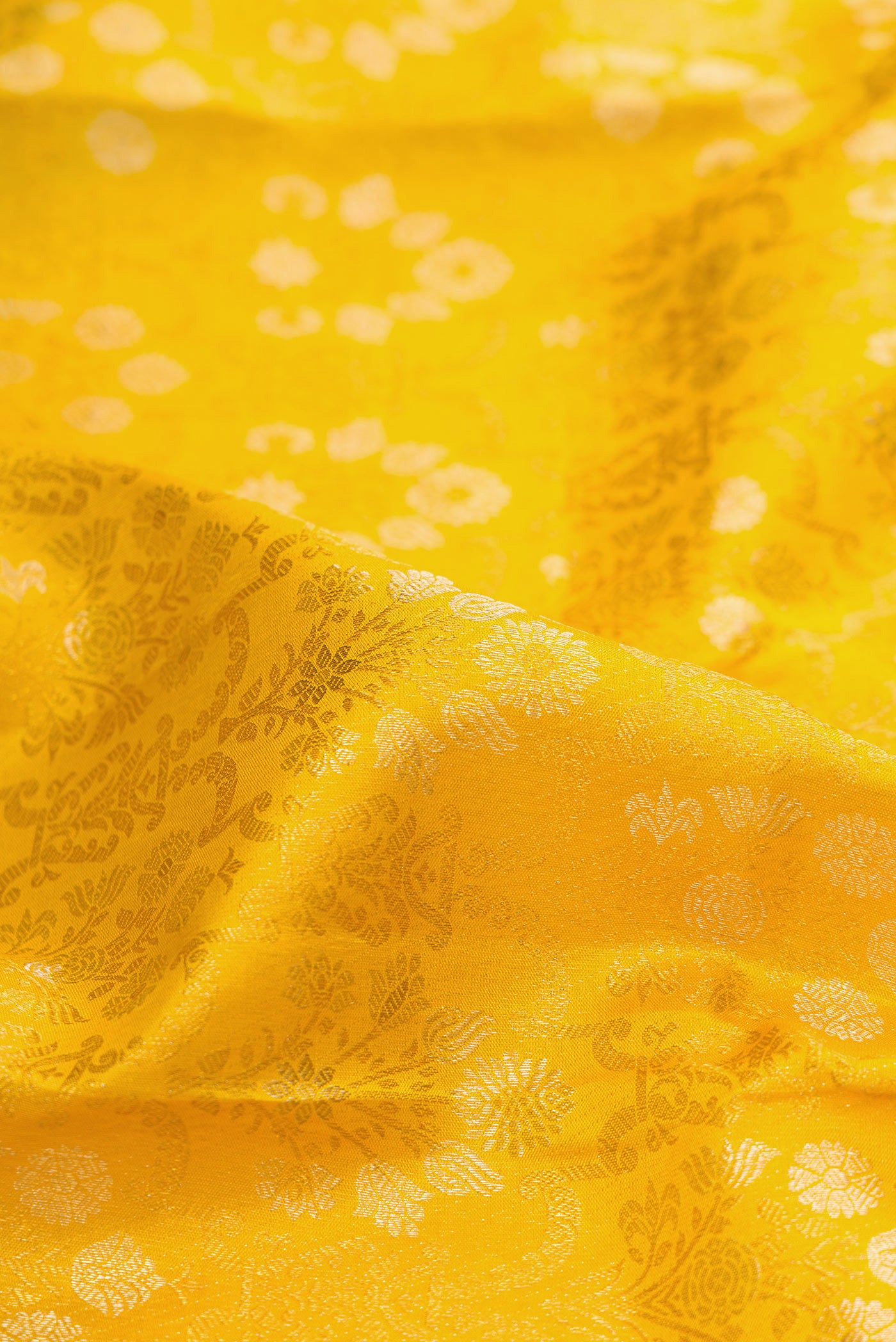 Close up of Pure Silk Mustard Kanjivaram Saree with Zari Brocade on the body and Zari Border.  displaying folds