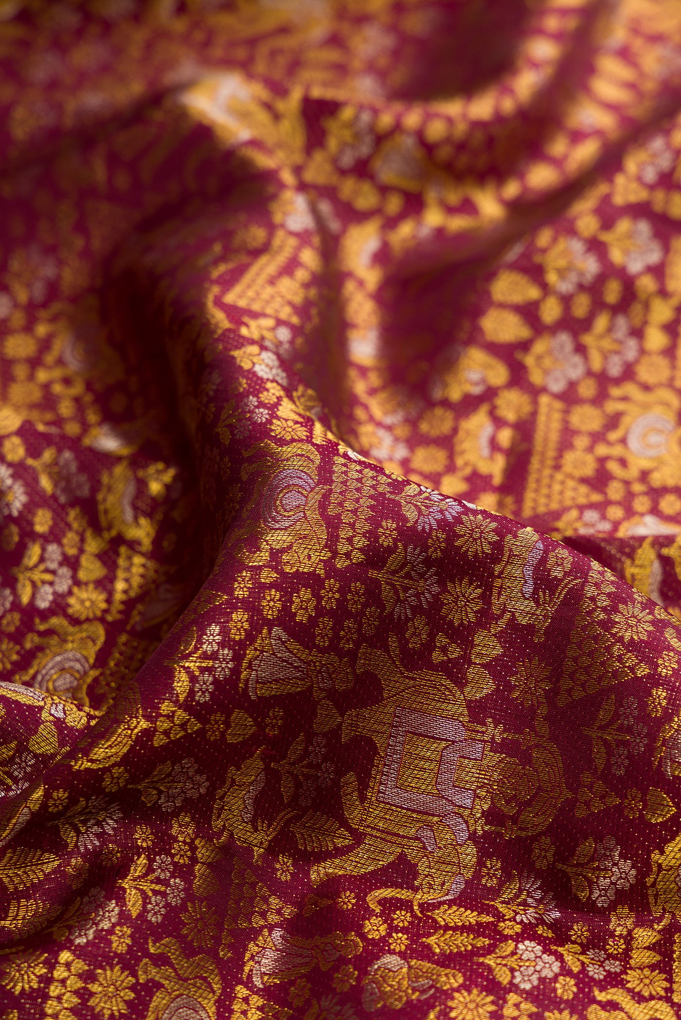 Close up of Pure Silk Maroon Kanjivaram Saree with Zari Brocade on the body and Zari Border.  displaying folds