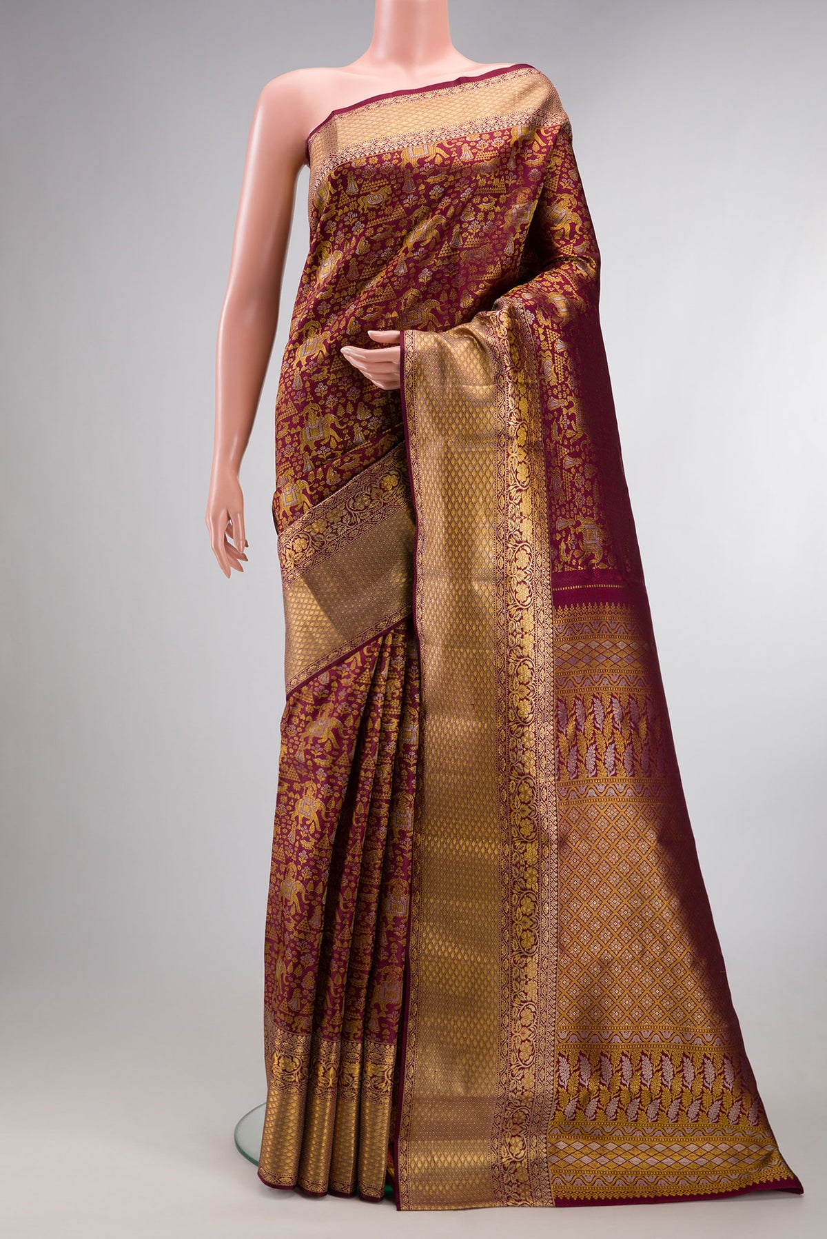 Pure Silk Maroon Kanjivaram Saree with Zari Brocade on the body and Zari Border.  displayed on a mannequin