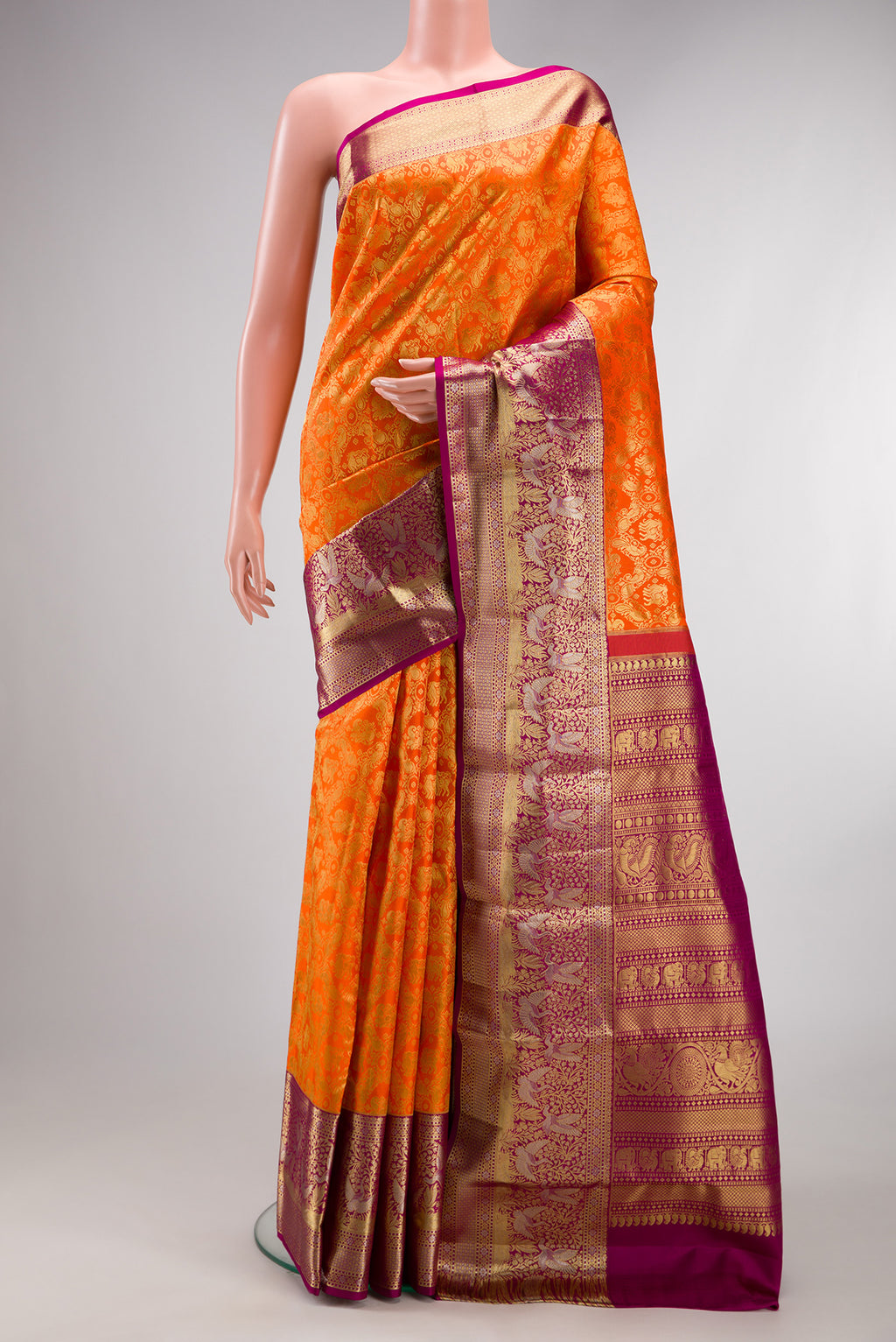 Pure Silk Orange Kanjivaram Saree with Zari Brocade on the body and Fancy Border.  displayed on a mannequin