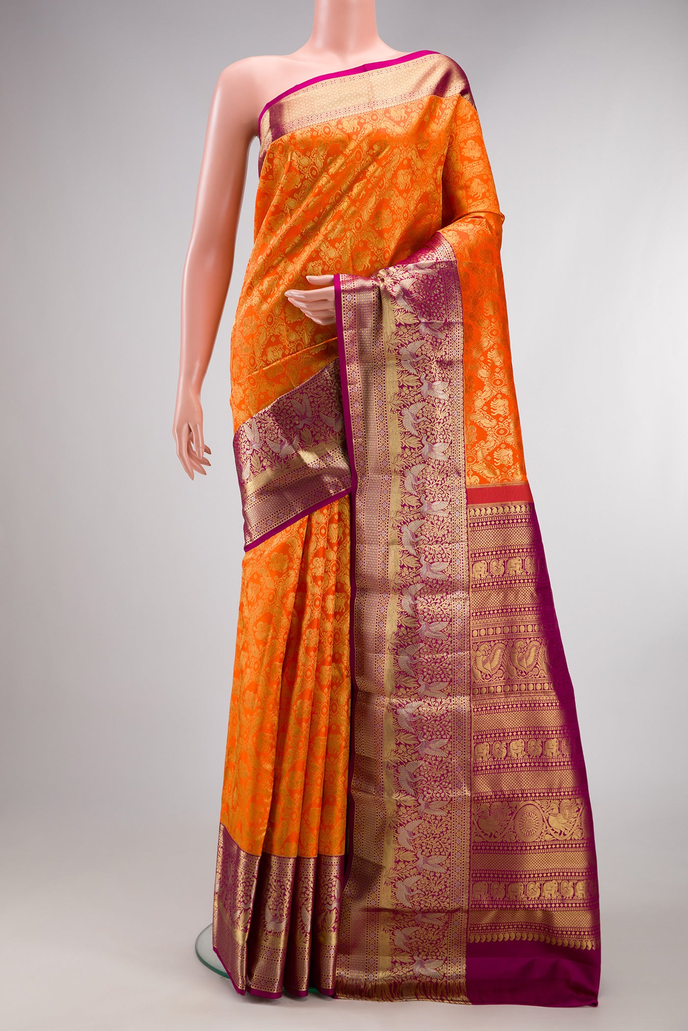 Pure Silk Orange Kanjivaram Saree with Zari Brocade on the body and Fancy Border.  displayed on a mannequin