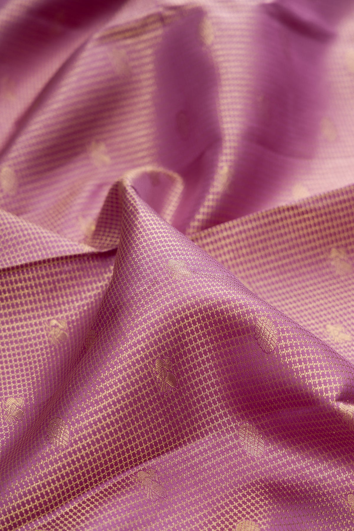 Close up of Pure Silk Mauve Dual Tone Kanchipuram Saree with Zari Brocade on the body and Zari Border.  displaying folds