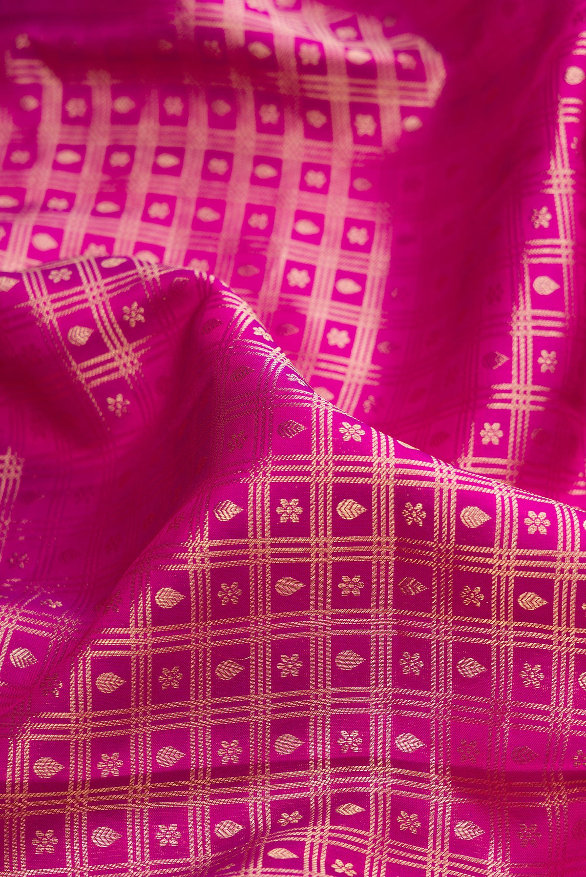 Close up of Pure Silk Rani Pink Kanchipuram Saree with Zari Brocade on the body and Fancy Border.  displaying folds