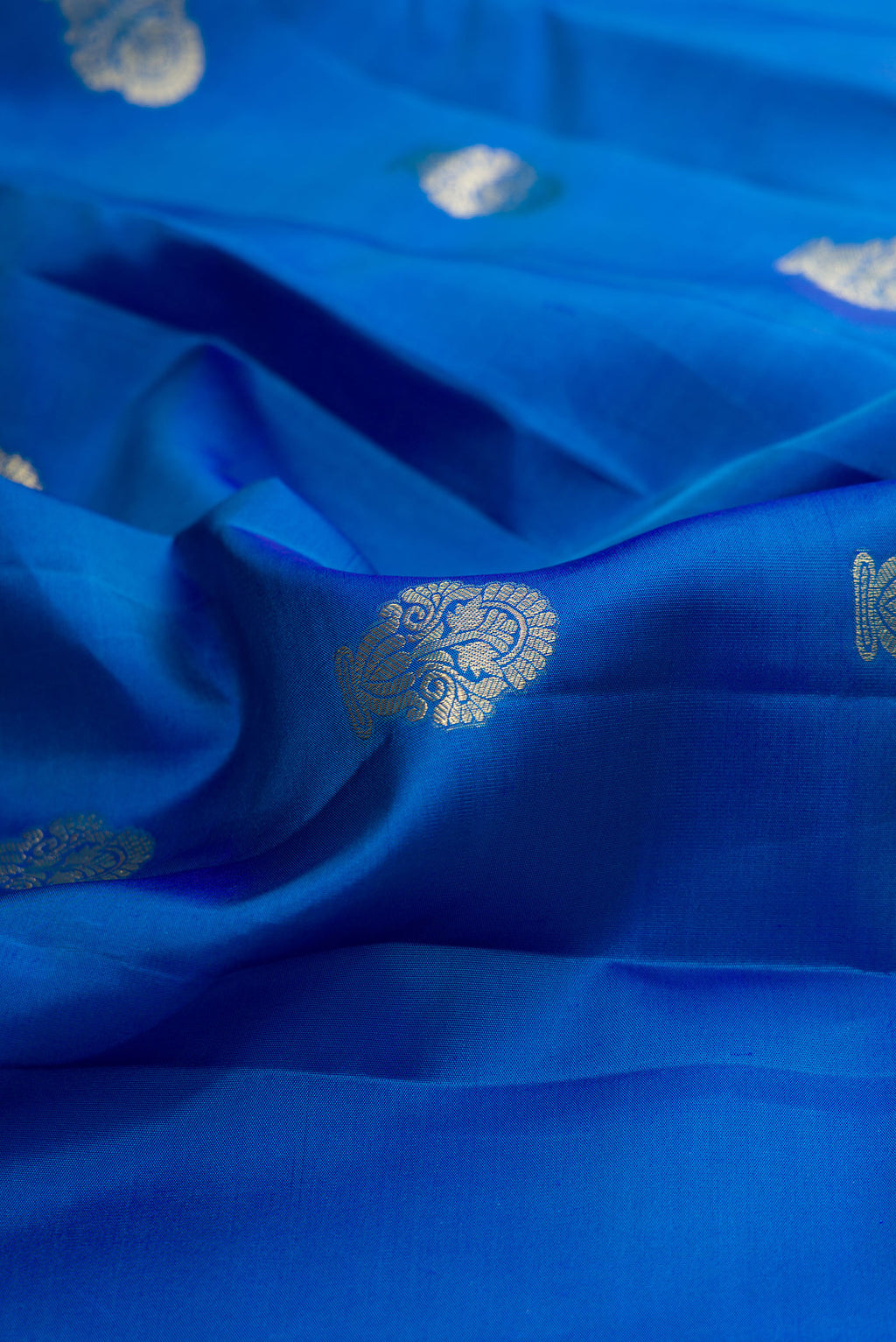 Close up of Pure Silk Peacock Blue Kanchipuram Saree with Zari Butta on the body and Fancy Border.  displaying folds