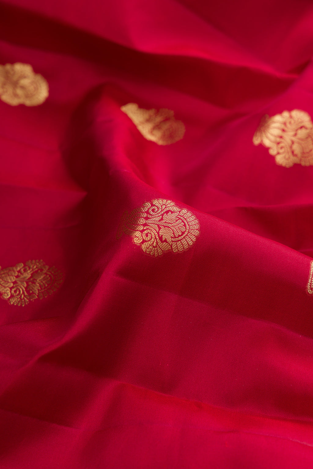 Close up of Pure Silk Maroon Kanchipuram Saree with Zari Butta on the body and Fancy Border.  displaying folds